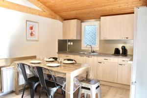 a kitchen with a wooden table with chairs and a counter at Domaine des Epinettes in Saint-Romain-de-Jalionas