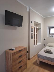 a bedroom with a dresser and a flat screen tv on the wall at La Giara in Spoleto