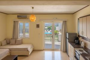 a living room with a bed and a kitchen with a balcony at Cavo Plako Villas in Palekastron
