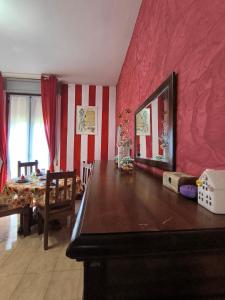 a dining room with a table and a red wall at L'armadio di Narni -A in Narni
