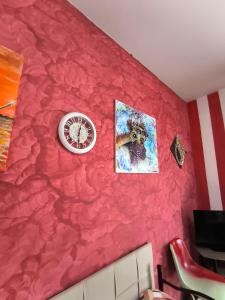 a red wall with a clock and an american flag at L'armadio di Narni -A in Narni