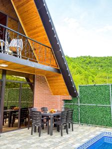 a patio with a table and chairs and a balcony at Lerik Forest House in Lerik