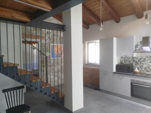 a kitchen with a spiral staircase in a house at L'Elefantino - Bed and Book in Roccasparvera
