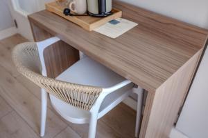 a wooden desk with a white chair and a table at Hotel Boutique La Brisa in Vilanova i la Geltrú