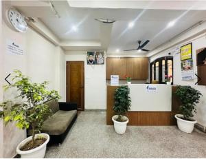 a lobby with a couch and two potted plants at Kashi Vilas in Varanasi