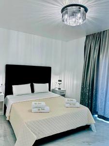 a bedroom with a large bed with two towels on it at Villa Koćuša in Ljubuški