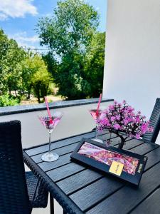 a table with a tablet and two glasses and flowers at Villa Koćuša in Ljubuški