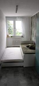 a bedroom with two beds and a window at Apartament w centrum in Biskupiec