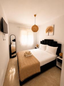 a bedroom with a large white bed and a television at Vigla summer house! in Paralia Sikias