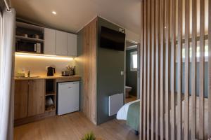 a room with a bed and a kitchen with a television at Camping As Cancelas in Santiago de Compostela +24 photos