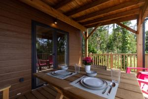 a table on the porch of a cabin at Camping As Cancelas in Santiago de Compostela