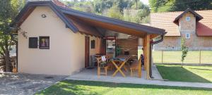 a small shed with a table and chairs in a yard at TEA Apartmani in Bajina Bašta