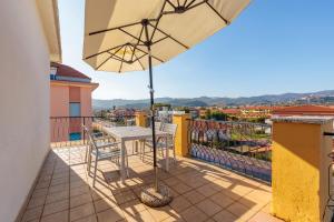 a table and chairs on a balcony with an umbrella at Hotel Residence Mediterraneo in Diano Marina