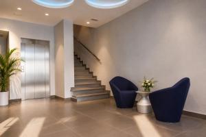 a lobby with blue chairs and a staircase at Hotel Boutique La Mar - Adults Only in Peniscola