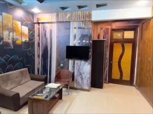 a living room with a couch and a tv at Hotel Serena in Hyderabad
