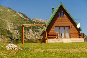 a log cabin with a swing in front of it at Durmitor Horizons in Žabljak