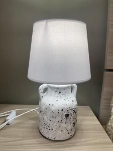 a white vase sitting on a table with a lamp at La Quiete dei Tacchi Ulassai in Ulassai
