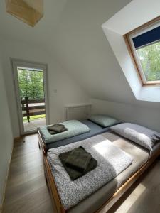 two beds in a room with a window at Przylądek Werlas in Werlas