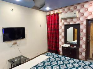 a bedroom with a bed and a tv and a mirror at Hotel Serena in Hyderabad