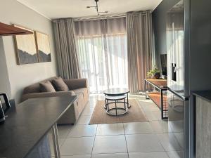 a living room with a couch and a table at 161 green valley in Boschrand +6 photos