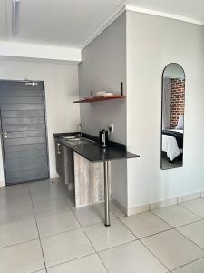 a kitchen with a counter with a sink and a mirror at 161 green valley in Boschrand