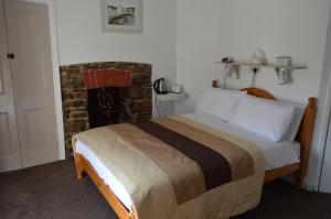 Un pat sau paturi într-o cameră la Smugglers Haunt Guest House