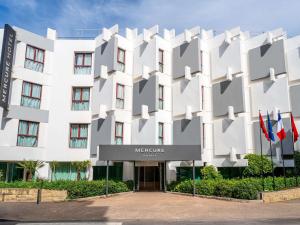a large white building with a sign in front of it at Mercure Shéhérazade Rabat in Rabat