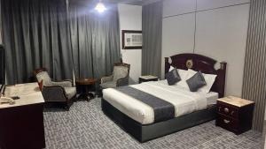 a hotel room with a bed and a desk and chairs at فندق الكراون نجران نجمه in Najran
