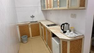 a small kitchen with wooden cabinets and a sink at فندق الكراون نجران نجمه in Najran