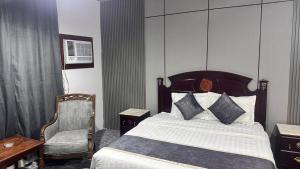 a hotel room with a bed and a chair at فندق الكراون نجران نجمه in Najran