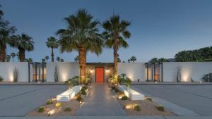 a house with palm trees and a red door at The Weekend by AvantSay in Palm Springs