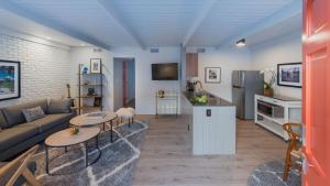 a living room with a couch and tables and a kitchen at The Weekend by AvantSay in Palm Springs