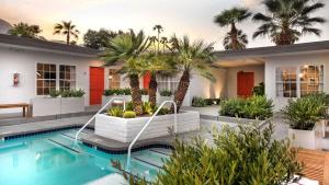 a house with a swimming pool with palm trees at The Weekend by AvantSay in Palm Springs
