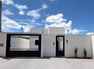 a white building with two gates on it at Wp White House- Estilo Grego 7 min do aqualinda in Andradina