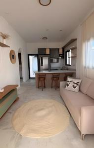 a living room with a couch and a kitchen at Wp White House- Estilo Grego 7 min do aqualinda in Andradina
