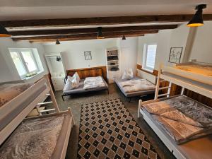 a room with three bunk beds and a checkered floor at Apartmány Moravský Kras Vavřinec in Vavřinec