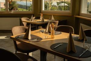 eine Reihe Tische in einem Restaurant mit Servietten darauf in der Unterkunft Hotel Roduna in Rodeneck