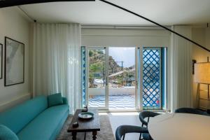 a living room with a blue couch and a window at La Prua in Taormina