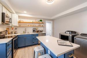 a kitchen with blue cabinets and a white counter top at Downtown WS bungalow Close to Everything in Winston-Salem