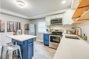 a kitchen with blue cabinets and a white counter top at Downtown WS bungalow Close to Everything in Winston-Salem