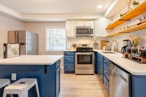 a kitchen with blue cabinets and a stove top oven at Downtown WS bungalow Close to Everything in Winston-Salem +17 photos