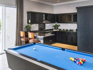 a pool table in the middle of a kitchen at Palmtree Luxury Villa Eden Rock Estate, Pennington in Pennington