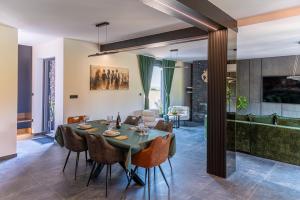 a dining room and living room with a table and chairs at Villa Novara Holiday Home in Lužan Biškupečki