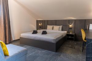 a bedroom with a large bed and a chair at Villa Novara Holiday Home in Lužan Biškupečki +58 photos