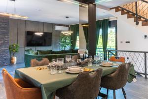 a dining room with a table and chairs and a couch at Villa Novara Holiday Home in Lužan Biškupečki
