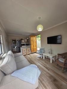 a living room with a couch and a tv at Beach cottage in Gonubie Park