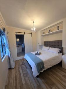 a bedroom with a large bed and a bathroom at Beach cottage in Gonubie Park