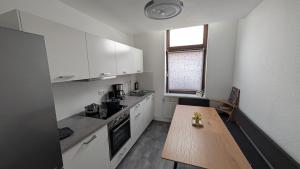 a kitchen with white cabinets and a wooden table at Ferienwohnung Lehmann in Wolfenbüttel