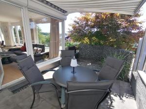 eine überdachte Veranda mit Tisch und Stühlen in der Unterkunft Ostalb-Spa in Leinzell