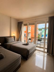 a hotel room with two beds and a balcony at Doze Bangla in Patong Beach +54 photos